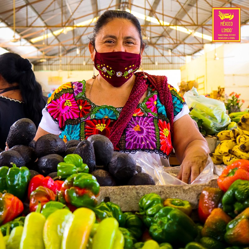 a person standing in front of a fruit stand