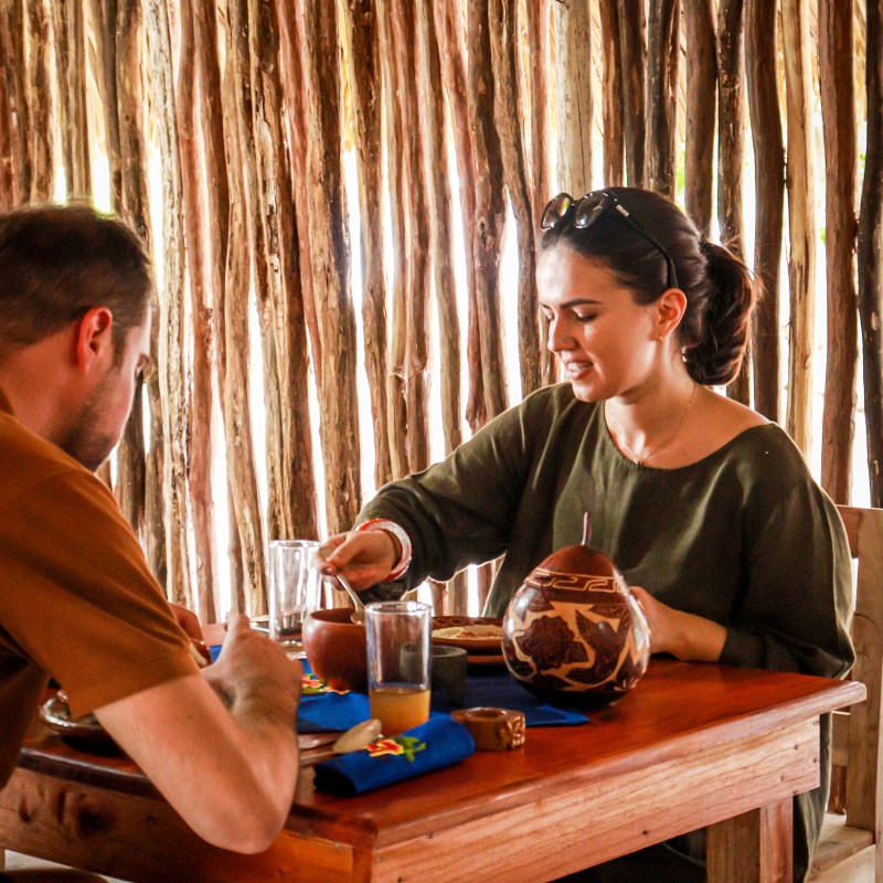 a man sitting at a table in front of a curtain