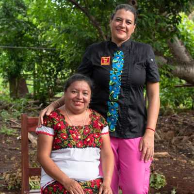 a little girl standing in front of a tree