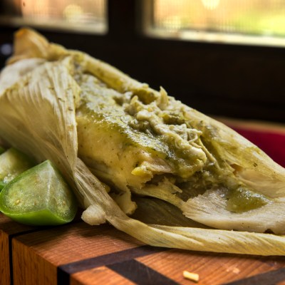 a close up of a sandwich sitting on top of a wooden cutting board