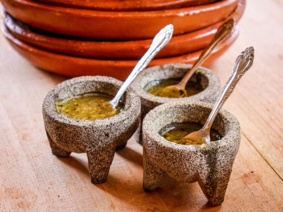 a bowl of fruit sitting on top of a wooden table