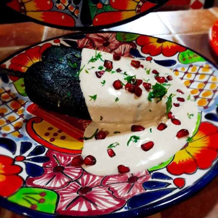 Traditional chiles en Nogada dish with creamy walnut sauce, pomegranate seeds and parsley, celebrating Mexico´s Independence Day and its vibrant culinary heritage